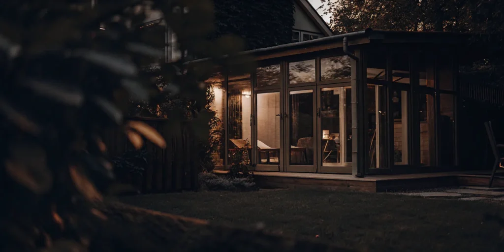 Bright add-on sunroom with comfortable furniture overlooking a garden.